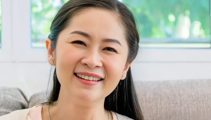 A close-up portrait of a smiling woman looking at the camera