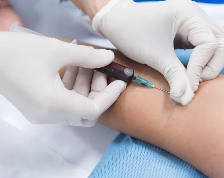 A healthcare provider drawing blood from a patient's arm