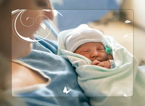 A mother smiling while holding her newborn baby after a successful birth.