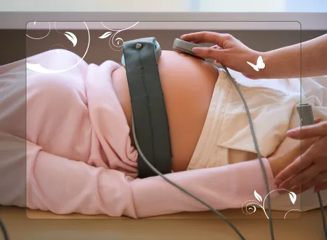 Pregnant woman undergoing a Foetal Wellbeing Assessment with a monitoring belt on her belly.